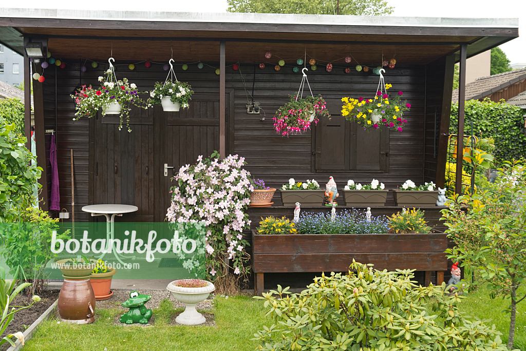 532005 - Gartenlaube mit bepflanzten Blumenampeln und Blumenkästen