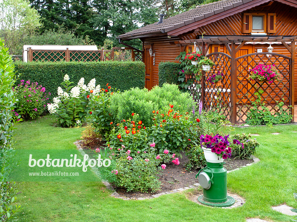 475245 - Hölzerne Gartenlaube und Blumenbeete in einem Kleingarten