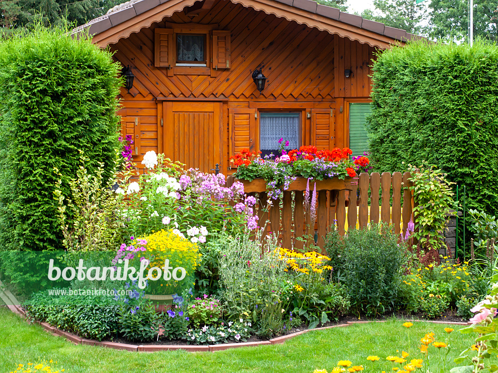 475246 - Hölzerne Gartenlaube und Blumenbeete in einem Kleingarten