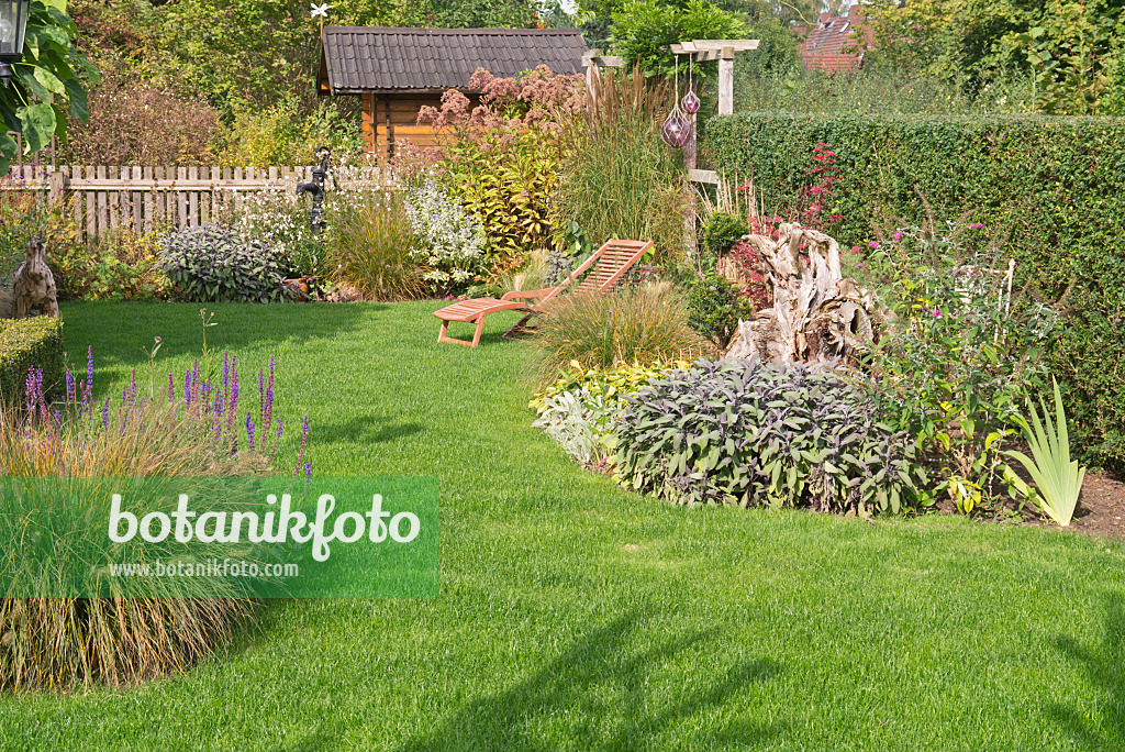 573106 - Autumnal perennial garden with deck chair