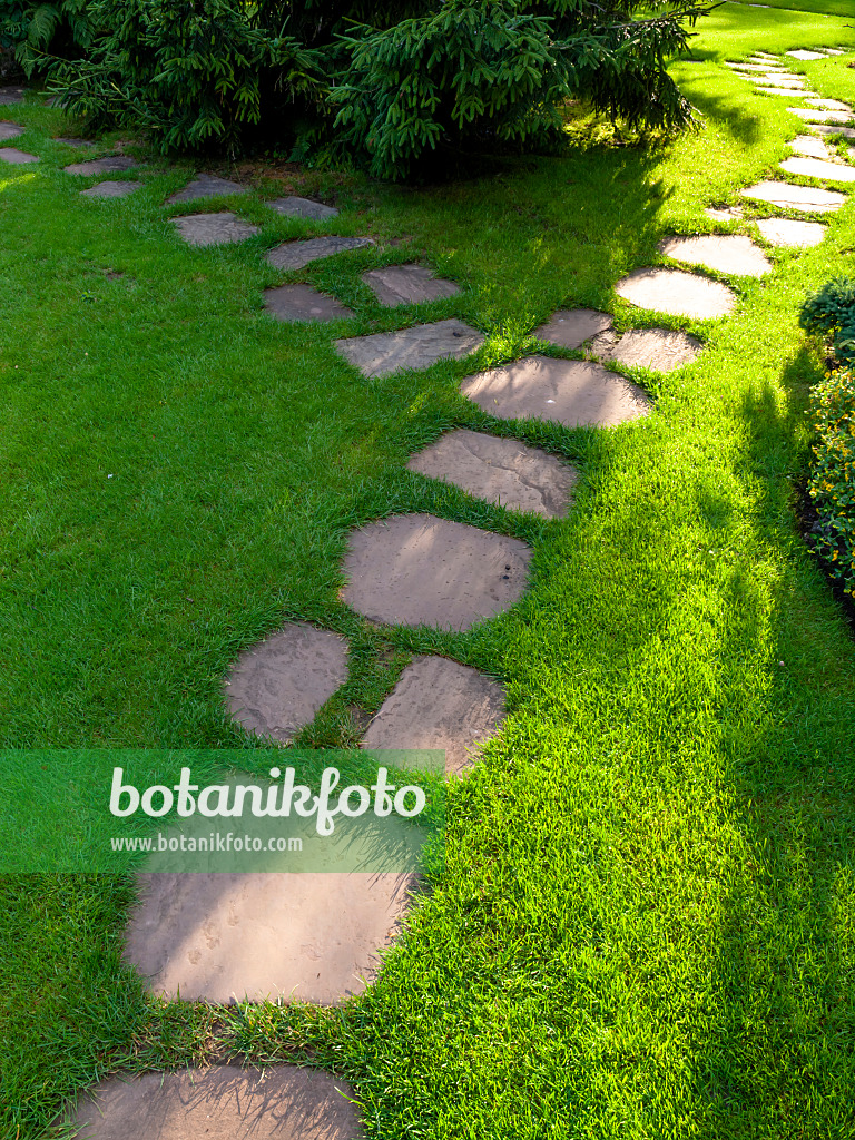 427086 - Garden path made of irregular stone slabs embedded in the lawn