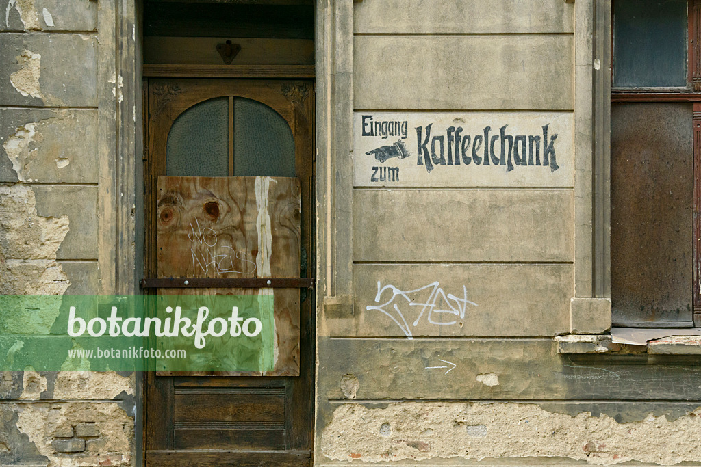 559060 - House entrance with a wooden door from the founding period and old advertisement on the house wall, Görlitz, Germany