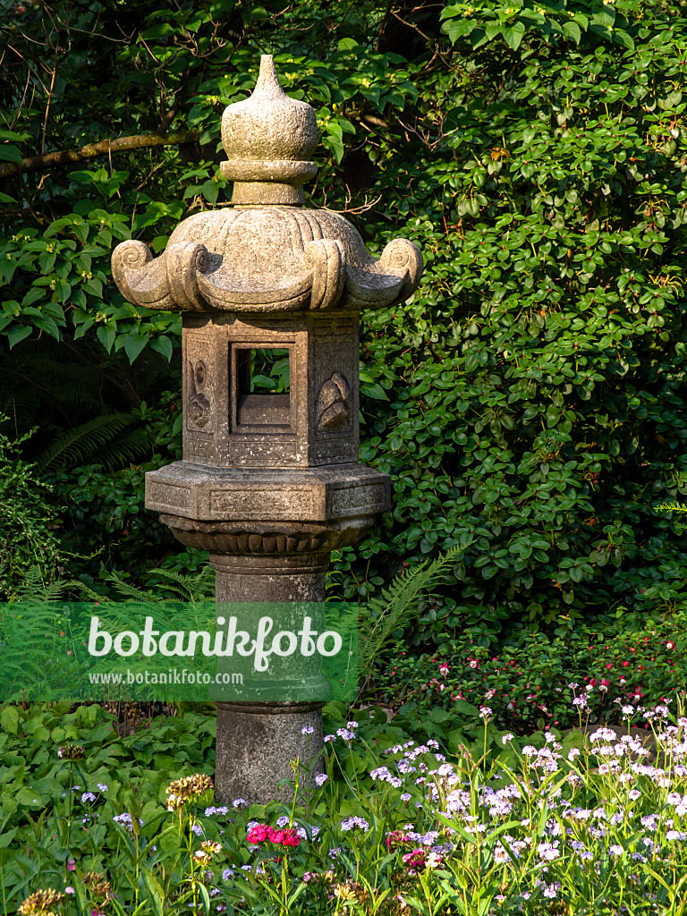 427088 - Large stone lantern with curved stone roof in a garden