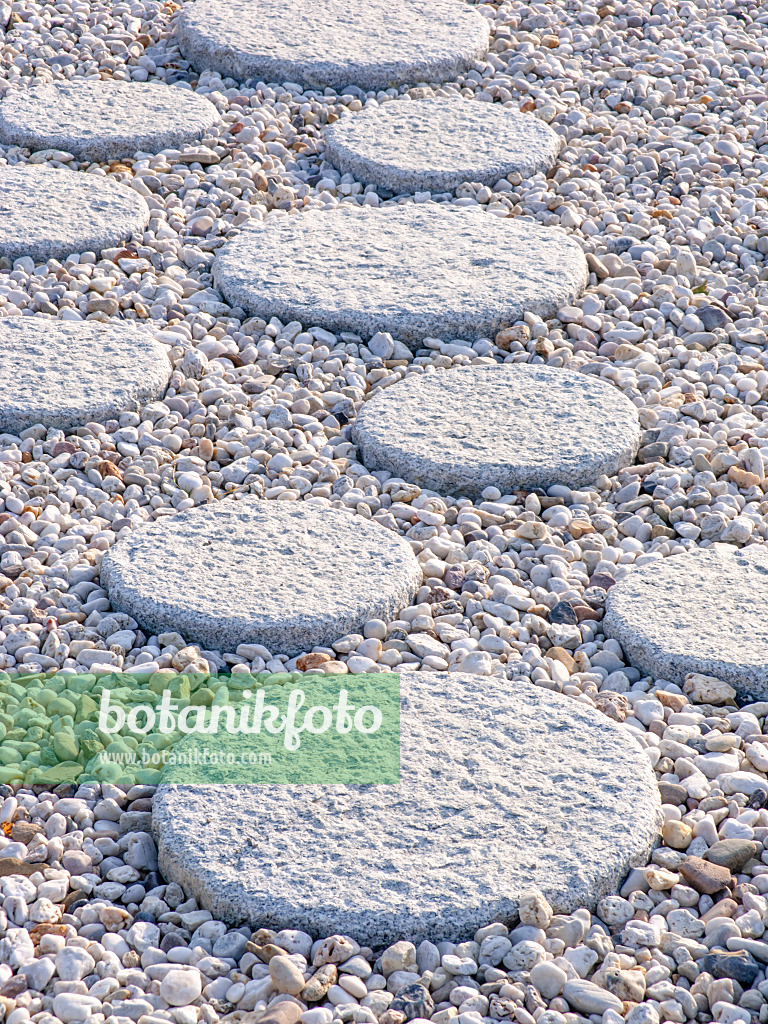 441182 - Round hewn path slabs in different sizes in a gravel bed