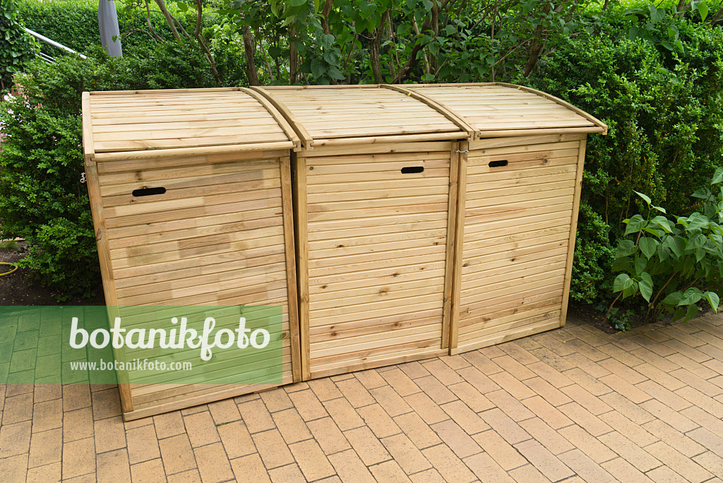 532030 - Trash bins with wooden lids on a terrace with stone tiles