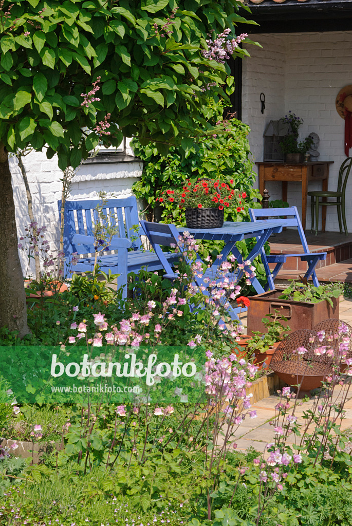 509158 - Salon de jardin avec des meubles bleus devant une maison blanche