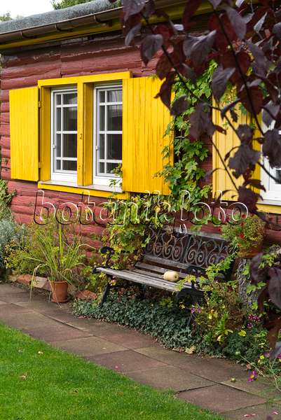 536212 - Gartenbank vor einem Haus mit gelben Fensterläden