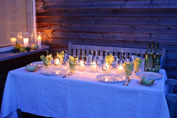 483035 - Gedeckter Tisch mit Kerzen auf einer Terrasse