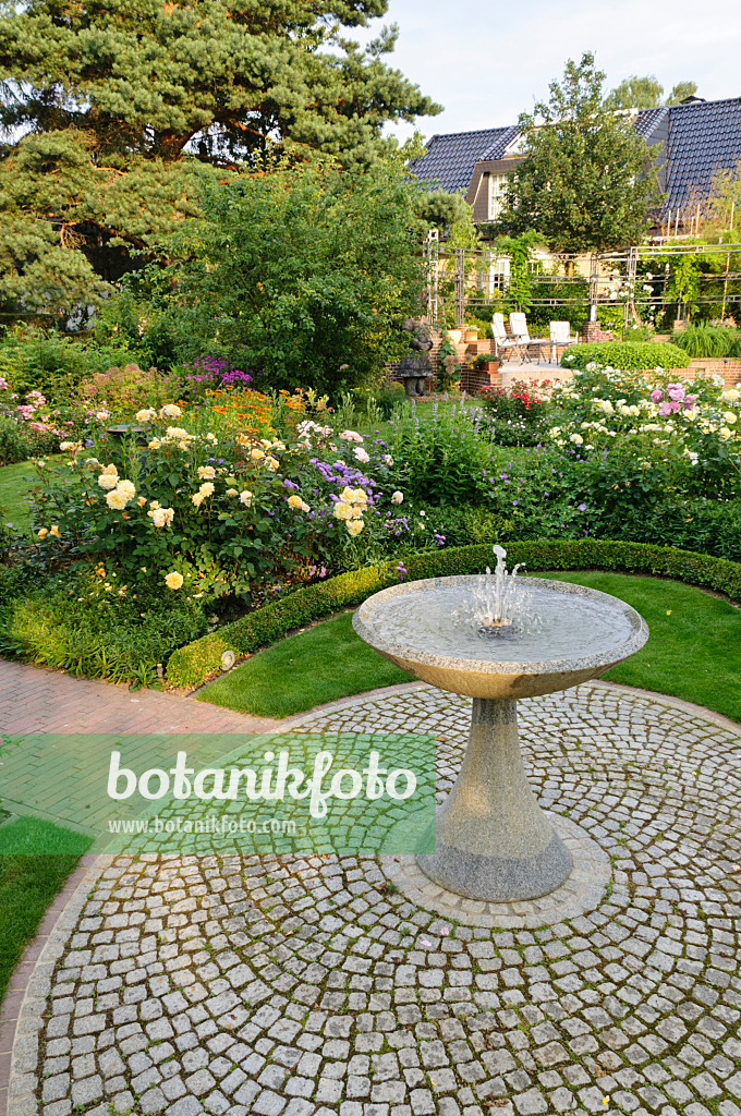 474072 - Granitbrunnen in einem Rosengarten