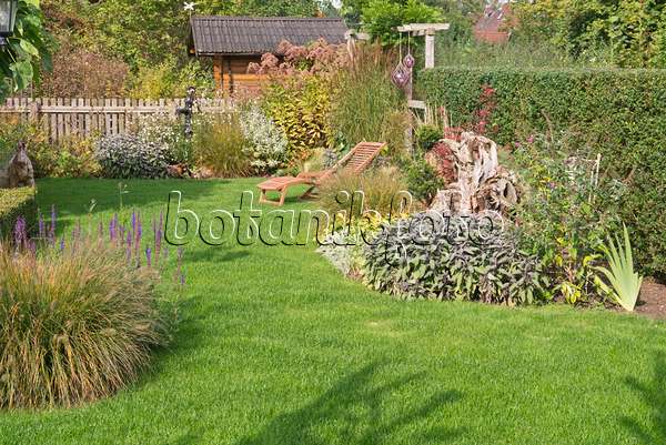 573106 - Autumnal perennial garden with deck chair