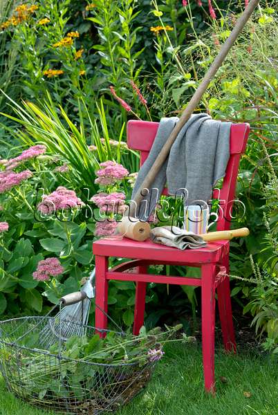 460002 - Chaise rouge avec des outils de jardinage