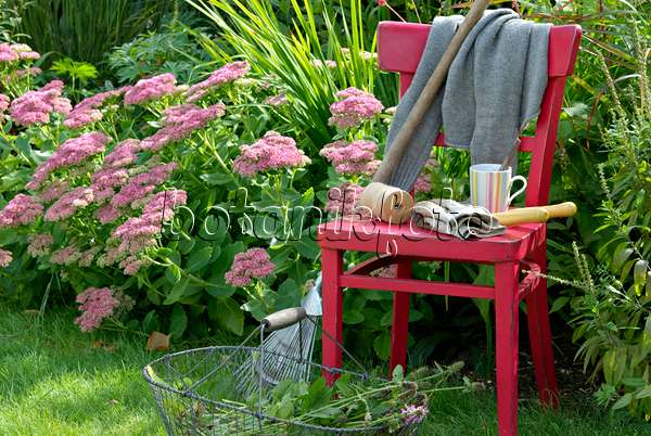 460003 - Chaise rouge avec des outils de jardinage