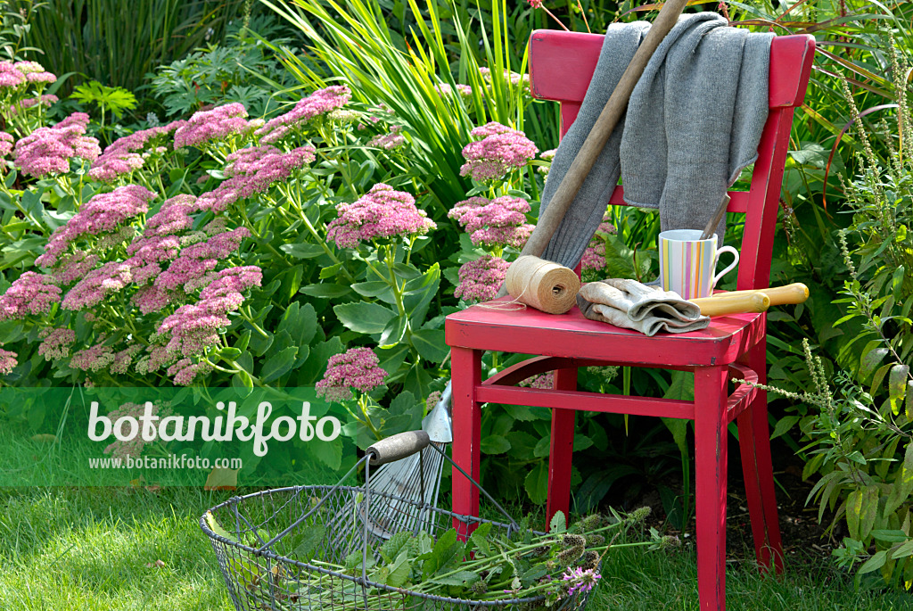 460003 - Chaise rouge avec des outils de jardinage