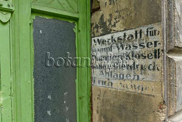559059 - House entrance with a green front door from the founding period and old advertisement at the house wall, Görlitz, Germany