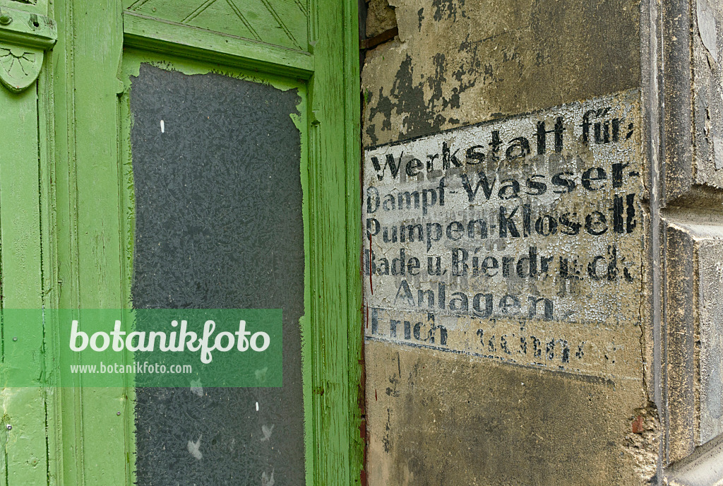 559059 - House entrance with a green front door from the founding period and old advertisement at the house wall, Görlitz, Germany