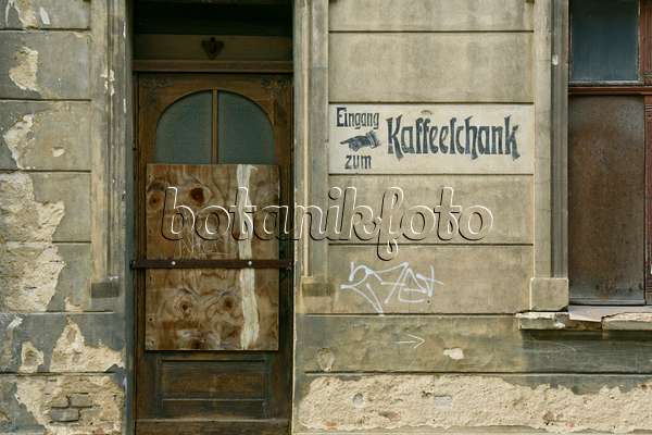 559060 - House entrance with a wooden door from the founding period and old advertisement on the house wall, Görlitz, Germany