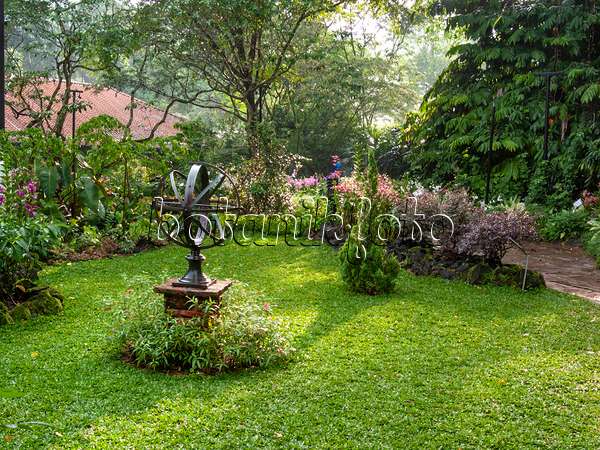 411187 - Objet d'art sur un piédestal en pierre dans un jardin tropical, Singapour