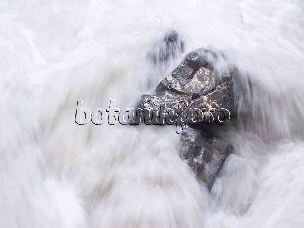 439164 - White spray over boulders of a falling mountain stream