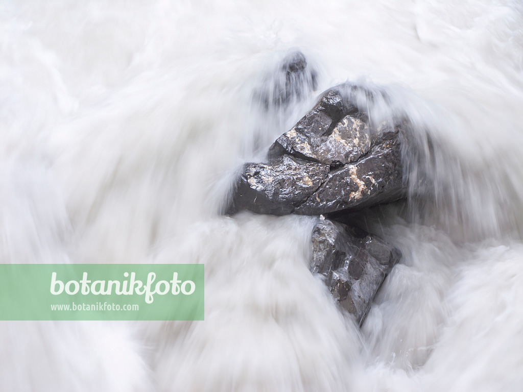 439164 - White spray over boulders of a falling mountain stream