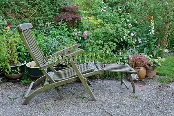472371 - Wooden deck chair with potted plants