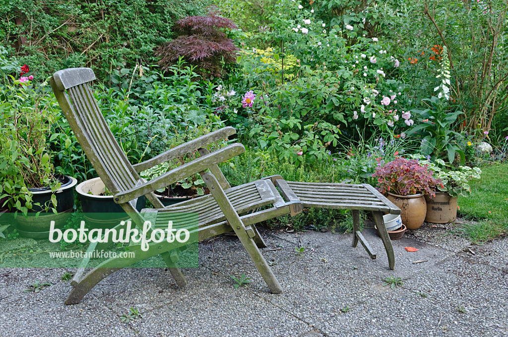 472371 - Wooden deck chair with potted plants