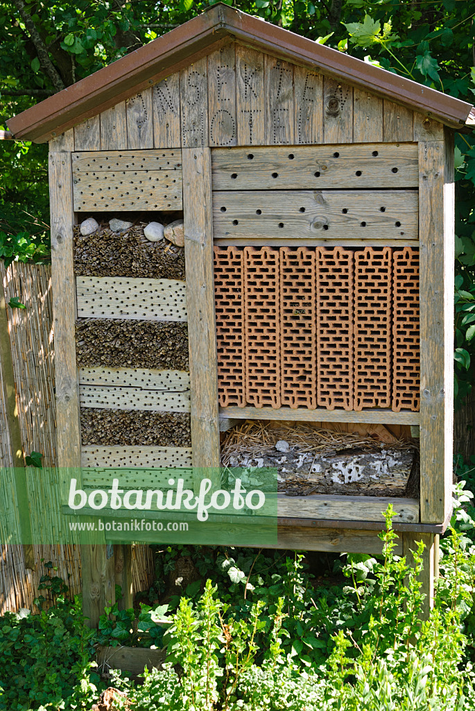 500197 - Große Nisthilfe für Insekten mit gelochten Ziegelsteinen, Ästen und Baumstämmen unter einem Giebeldach