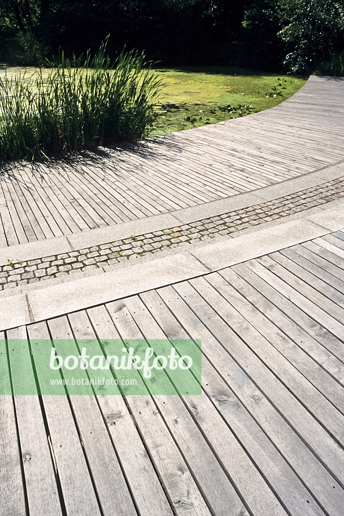 392046 - Large terrace with wooden slats and paving stones in front of an idyllic garden pond