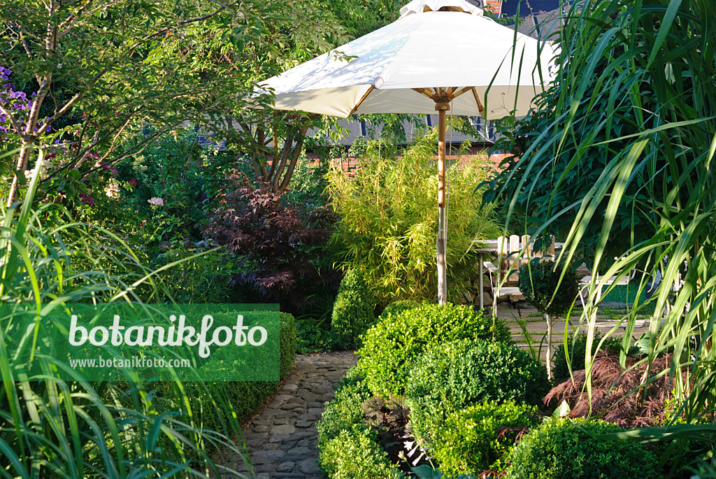 475271 - Petit jardin formel avec coin salon et parasol