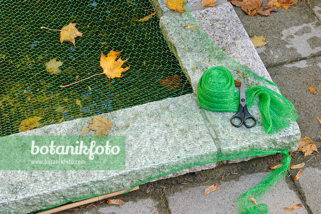 517004 - Protecting garden pond with a net against autumn leaves (2)