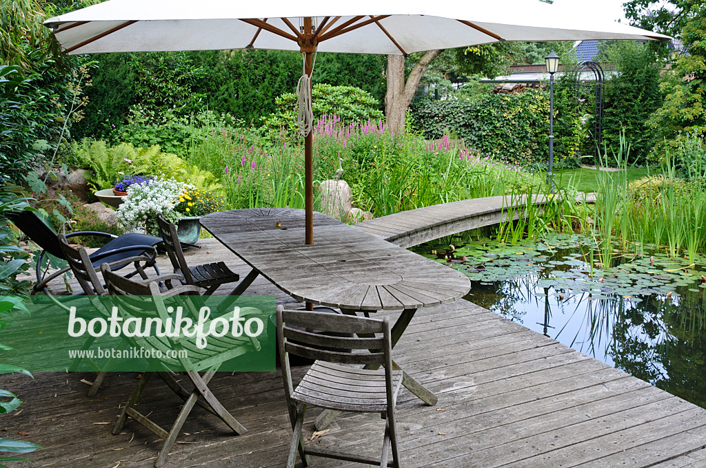 474042 - Terrasse en bois avec sièges au bord d'un étang de baignade