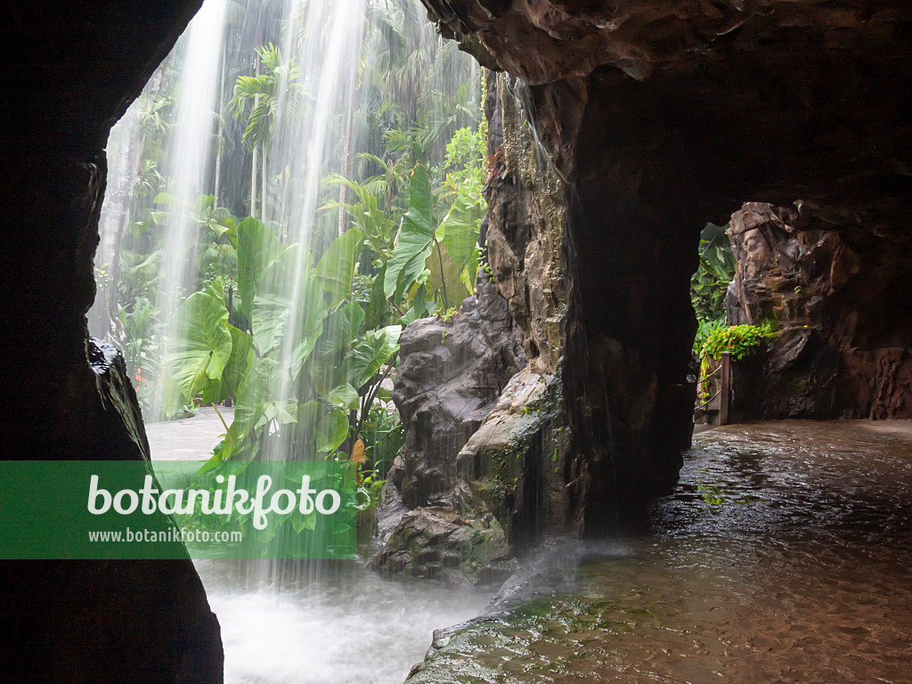411144 - Water spray at a waterfall in front of a dark rock grotto