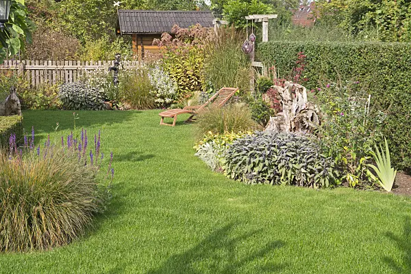 573106 - Autumnal perennial garden with deck chair