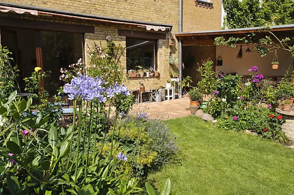 474344 - Backyard garden with perennial beds, lawn and terrace with potted plants