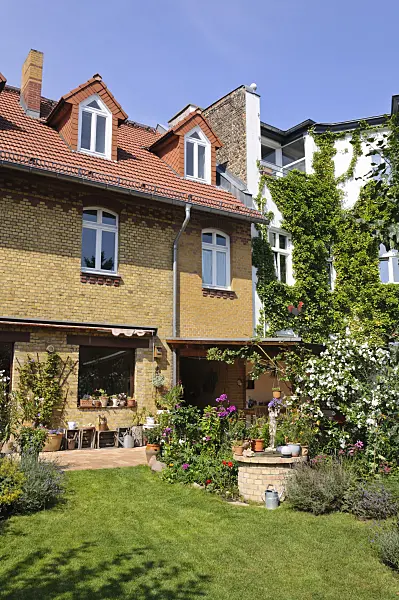 474345 - Backyard garden with perennial beds, lawn and terrace with potted plants