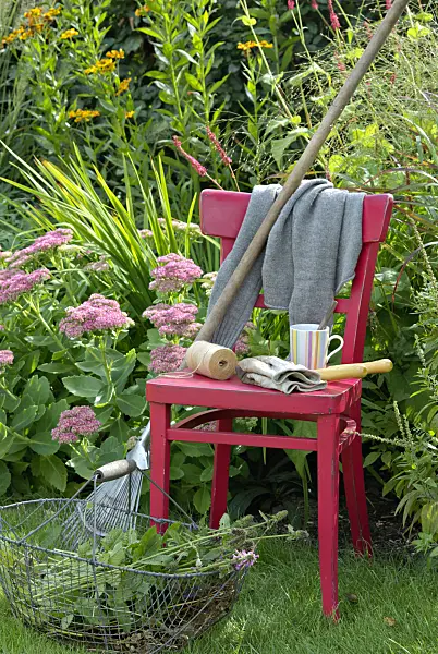 460002 - Chaise rouge avec des outils de jardinage