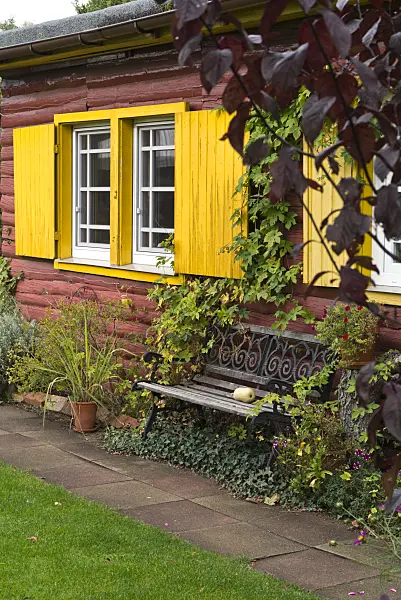 536212 - Garden bench in front of a house with yellow shutters