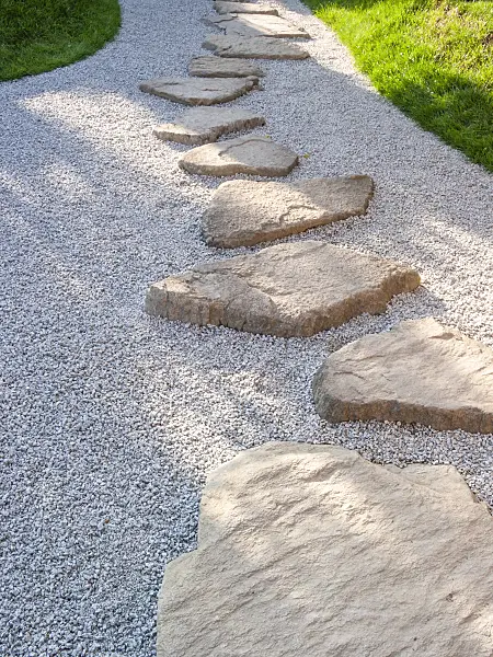 416075 - Garden path made of individually laid hewn stone slabs in a gravel bed