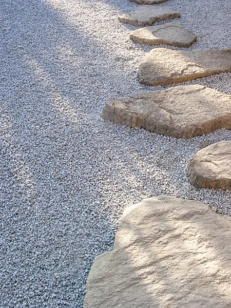 416076 - Garden path made of individually laid hewn stone slabs in a gravel bed