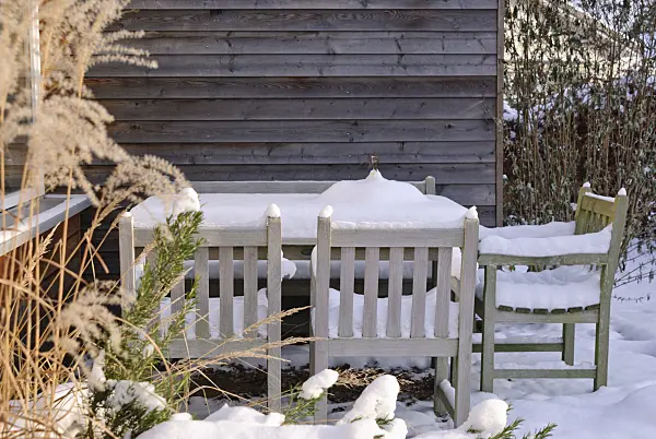 483026 - Garden table and chairs on a terrace in snow