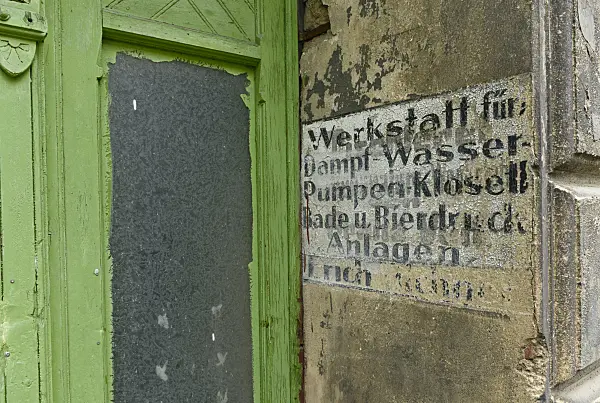 559059 - House entrance with a green front door from the founding period and old advertisement at the house wall, Görlitz, Germany