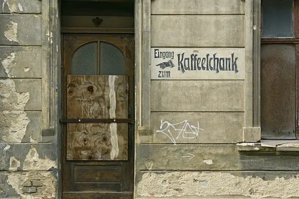 559060 - House entrance with a wooden door from the founding period and old advertisement on the house wall, Görlitz, Germany