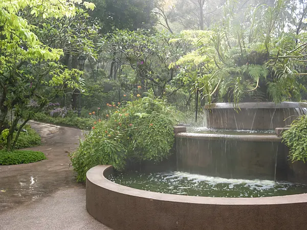 411184 - Large fountain with spray in a tropical garden in Singapore