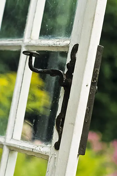 381096 - Muntin door with glass panes and iron handle of an old garden house
