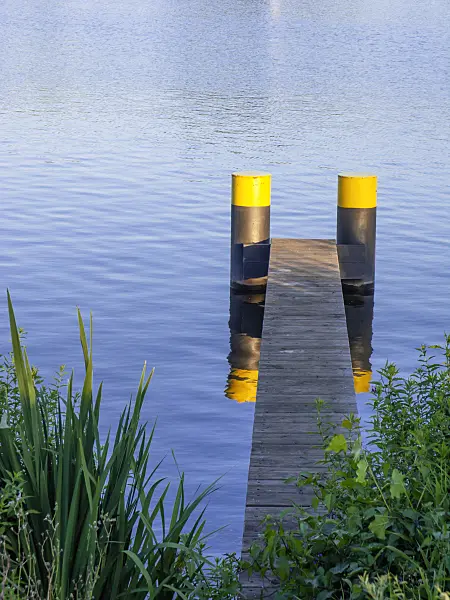 451018 - Narrow jetty made of wooden slats with two pontoons painted in yellow-black with blue water