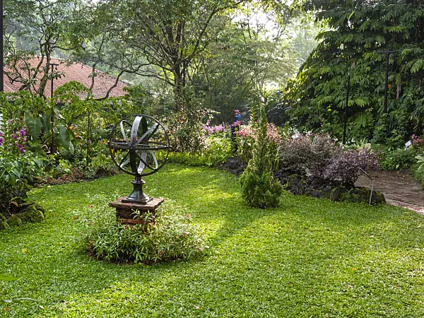 411187 - Objet d'art sur un piédestal en pierre dans un jardin tropical, Singapour