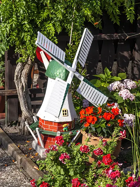 441012 - Petit moulin à vent coloré dans un jardin de fleurs