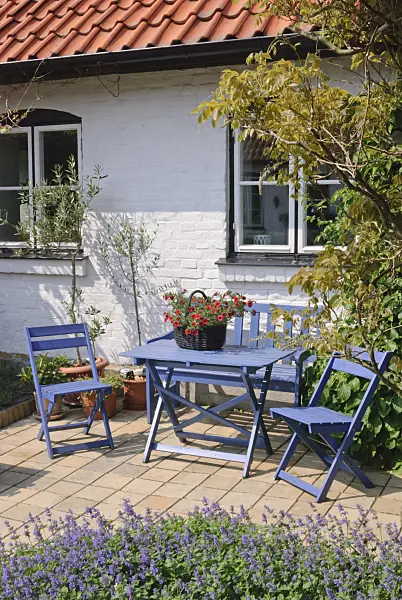 509157 - Salon de jardin avec des meubles bleus devant une maison blanche
