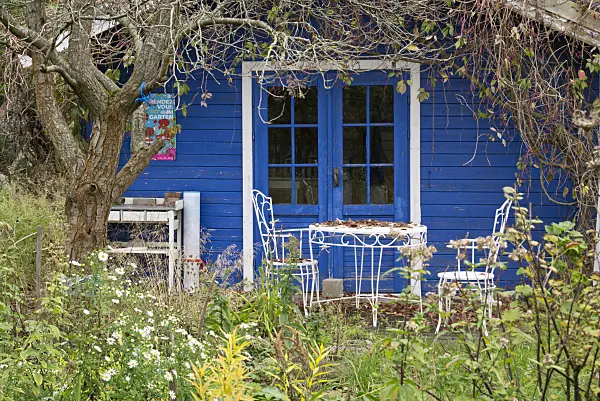 609041 - Seating area in front of a blue garden house