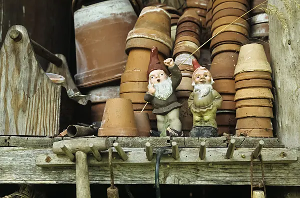 429258 - Stacked flower pots and two garden gnomes in an old wooden rack