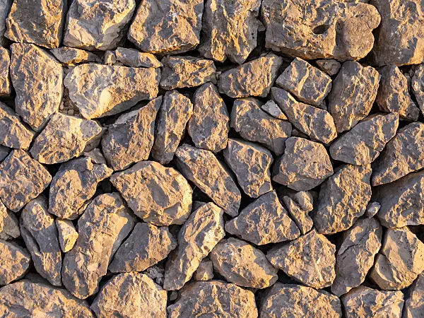 424042 - Stone wall made of randomly hewn stones in sunlight